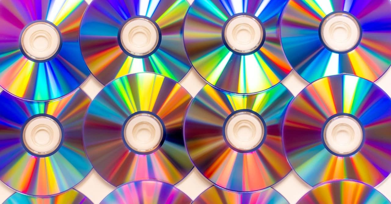 CDs e um aparelho de reprodução de música usados para ilustrar a volta da mídia física