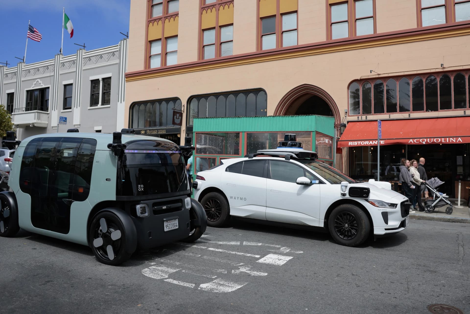 Táxis autônomos Waymo e Zoox circulando em uma rua de São Francisco