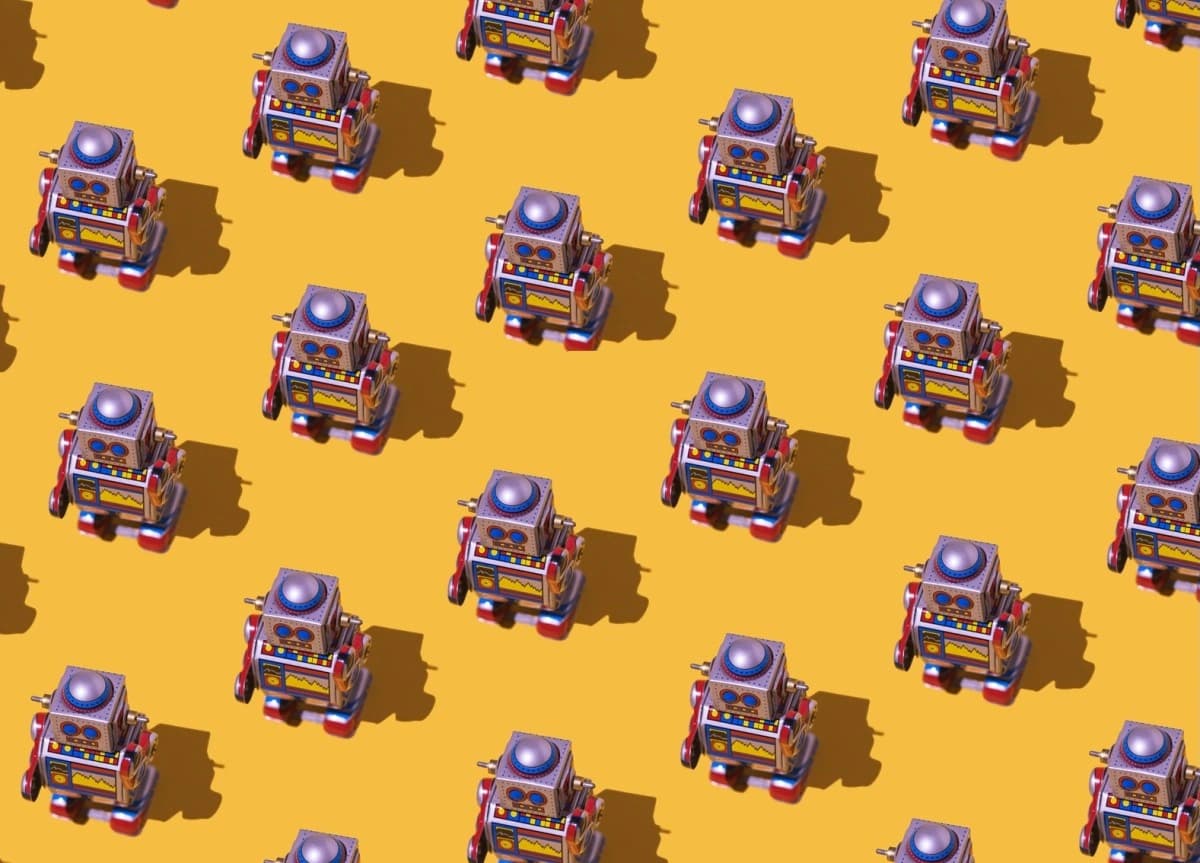 Padrão de robôs de brinquedo retrô sobre fundo amarelo, usado para ilustrar o excesso de submissões automatizadas em programas de recompensa por bugs