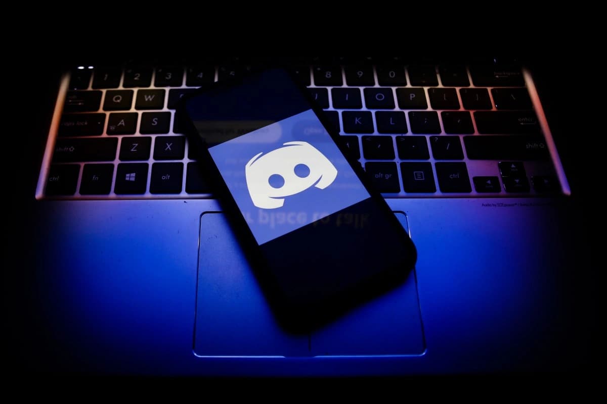 Logotipo do Discord exibido em uma tela de celular sobre um teclado
