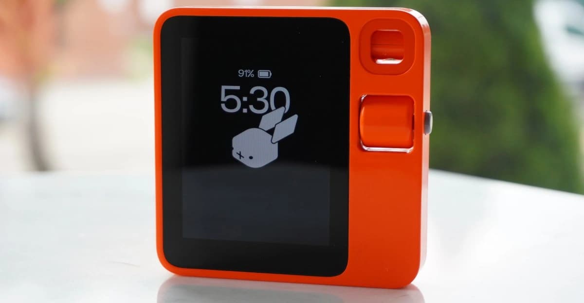 Dispositivo Rabbit R1 diante de uma janela
