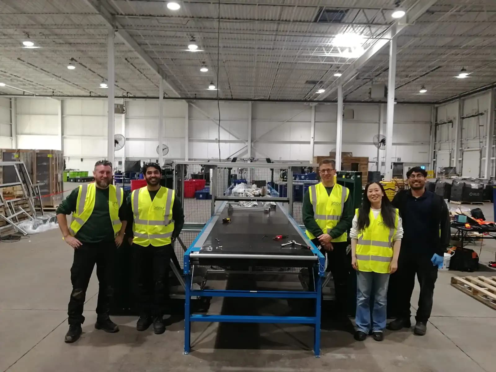 Equipe da Danu Robotics ao lado de um robô instalado para separar materiais recicláveis